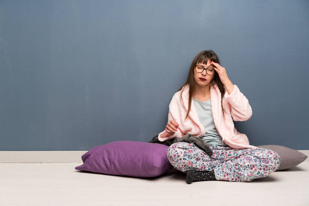 Woman in pajamas on the floor with headache - Фото, изображение