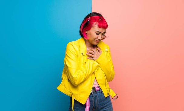 Young woman with yellow jacket having a pain in the heart - Foto, imagen