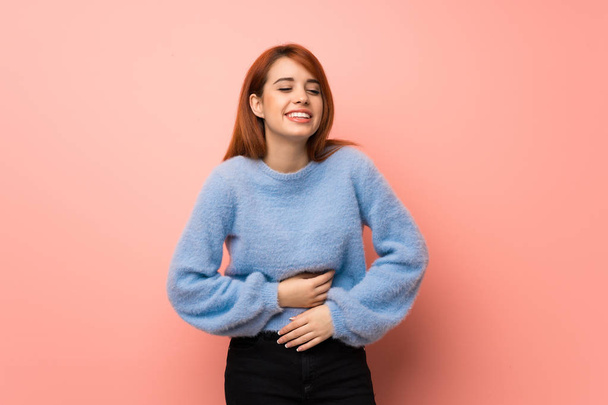 Young redhead woman over pink background smiling a lot while putting hands on chest - Foto, Imagen