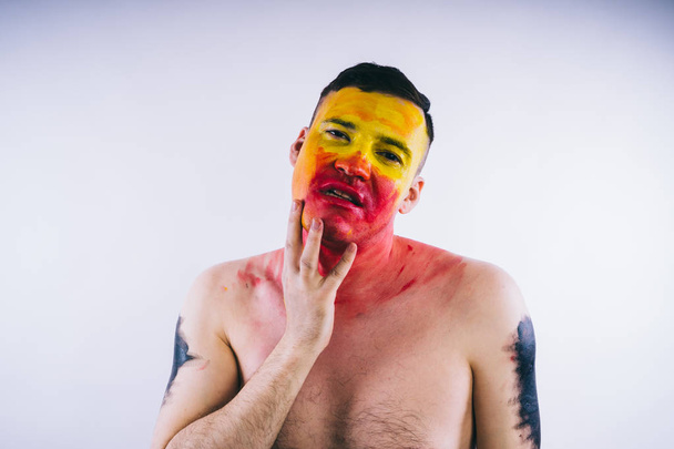young man with painted yellow red face. Soccer fan - Фото, зображення