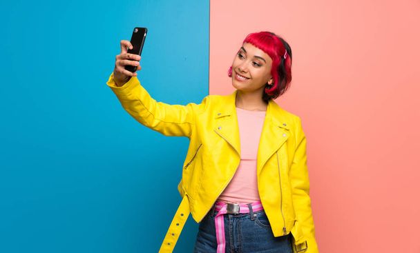 junge Frau mit gelber Jacke macht ein Selfie - Foto, Bild