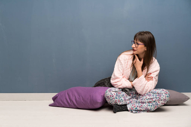 Woman in pajamas on the floor looking to the side - Photo, Image