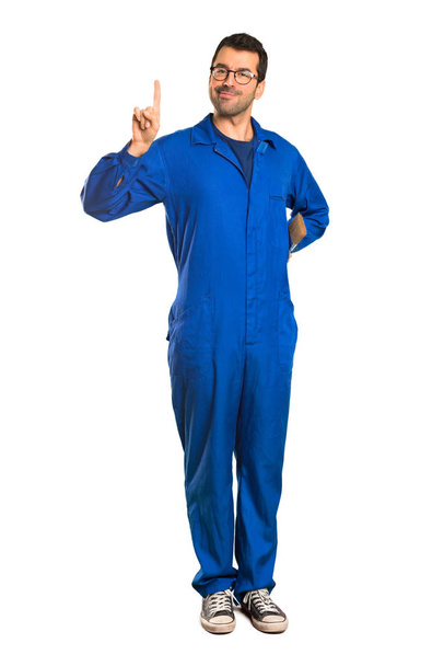 A full-length shot of a Painter man showing and lifting a finger in sign of the best on isolated white background - Photo, Image