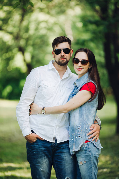Portrait of young happy couple in love, smiling and embracing in garden. - Photo, Image