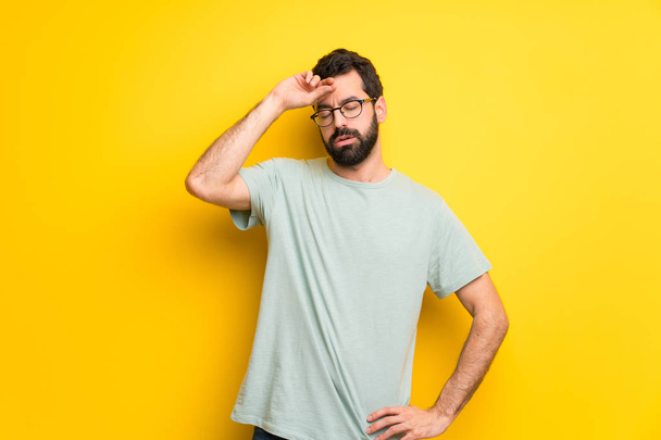 Man with beard and green shirt with tired and sick expression - Photo, Image