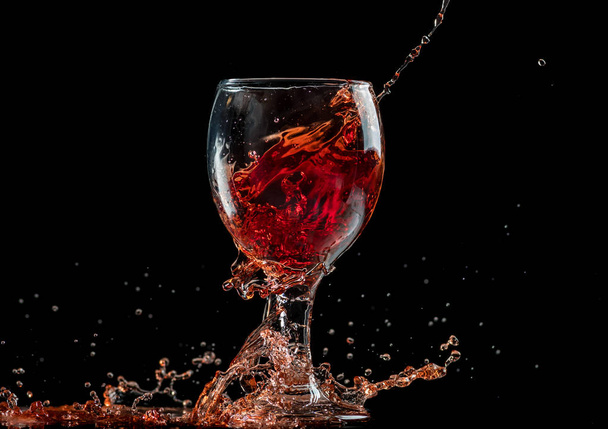 splash and flow from red wine in a glass, speed freeze - Foto, afbeelding
