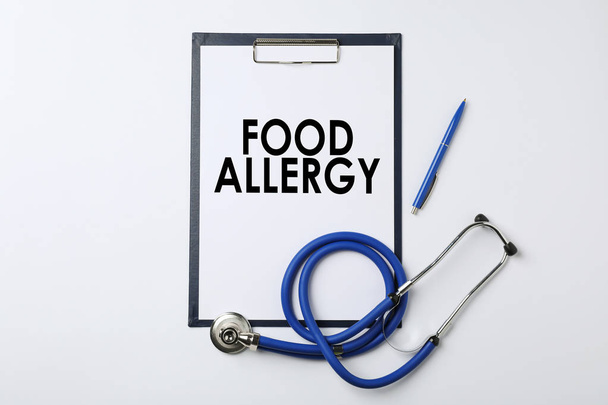 テキスト食物アレルギー、ペンと白い背景、上面の聴診器を使用してクリップボード - 写真・画像