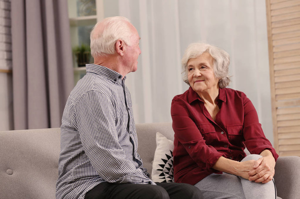 Retrato de cônjuges seniores sentados no sofá em casa para idosos
 - Foto, Imagem