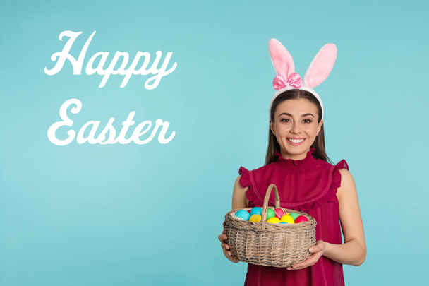 Belle femme dans les oreilles de lapin bandeau tenant panier avec des œufs sur fond de couleur. Joyeuses Pâques
 - Photo, image