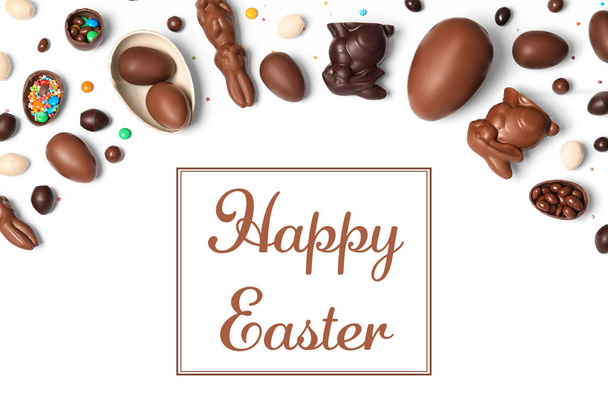 Flat lay composition with chocolate eggs and text Happy Easter on white background - Foto, afbeelding