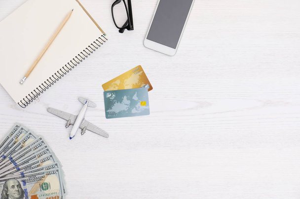Composición plana con tarjetas de crédito y modelo plano sobre mesa de madera en agencia de viajes
 - Foto, imagen