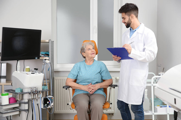 Senior woman visiting otolaryngologist in clinic. Hearing aid - Фото, изображение
