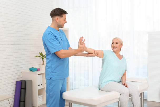 Physiotherapist working with patient in clinic. Rehabilitation therapy - Foto, Bild