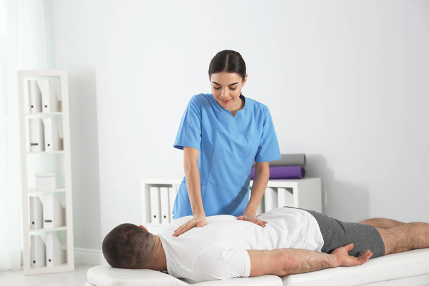 Doctor working with patient in hospital. Rehabilitation massage - Foto, afbeelding