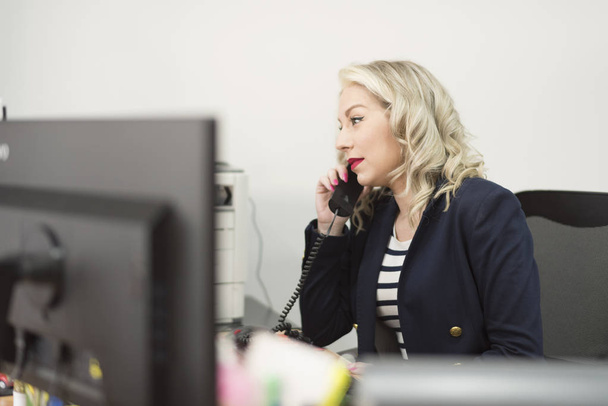 Attractive 30s woman working at office with telephone - Photo, Image