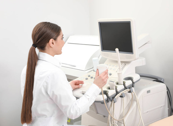 Professional sonographer using modern ultrasound machine in clinic - Foto, Imagem