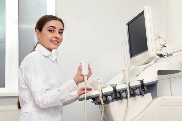 Professional sonographer using modern ultrasound machine in clinic - Fotoğraf, Görsel