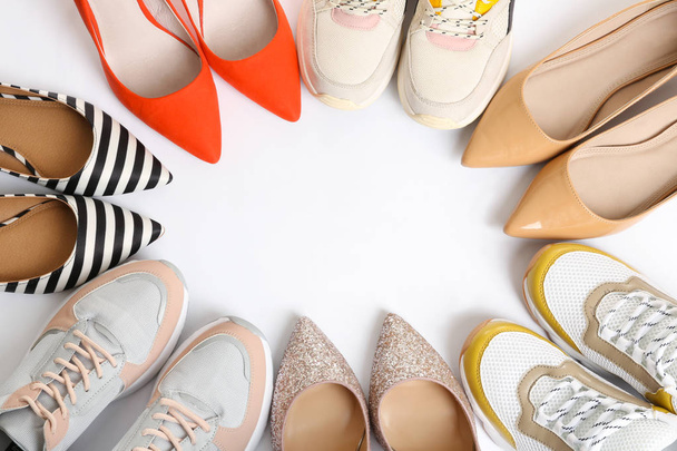 Frame of different shoes on white background, top view with space for text - 写真・画像