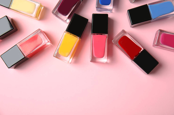 Bottles of nail polish on color background, top view with space for text - Zdjęcie, obraz