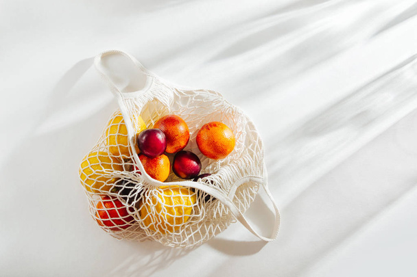 Cotton net bag with fruits. Sustainable lifestyle.  Eco friendly concept. - Fotoğraf, Görsel