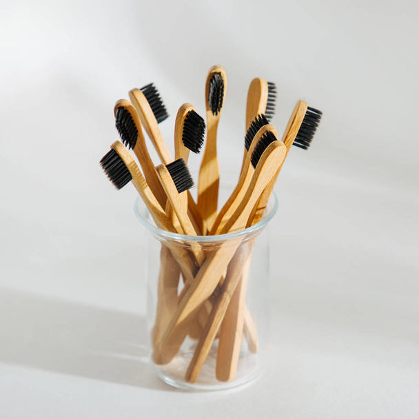 Eco friendly bamboo toothbrushes with black bristle, bathroom essentials on white background. Zero waste, plastic free concept.  - 写真・画像
