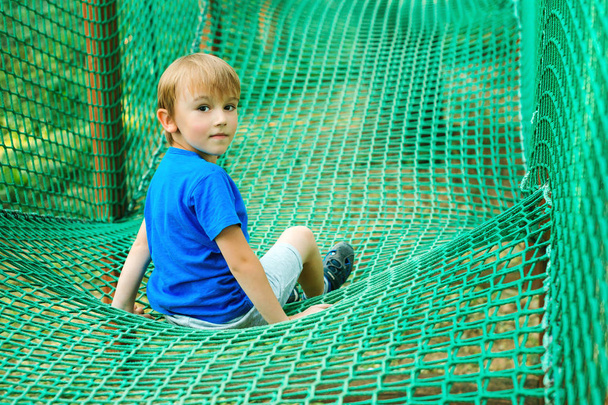 Šťastný chlapec baví v parku dobrodružství. Dítě hrající na venkovní hřiště.  - Fotografie, Obrázek