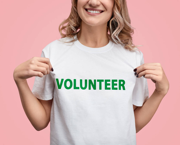 Crop female showing volunteer T-shirt - Foto, imagen