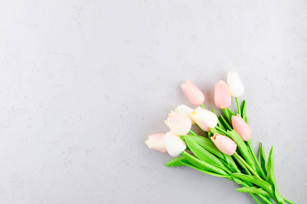 bouquet of light pink tulips on a gray concrete background - Фото, изображение