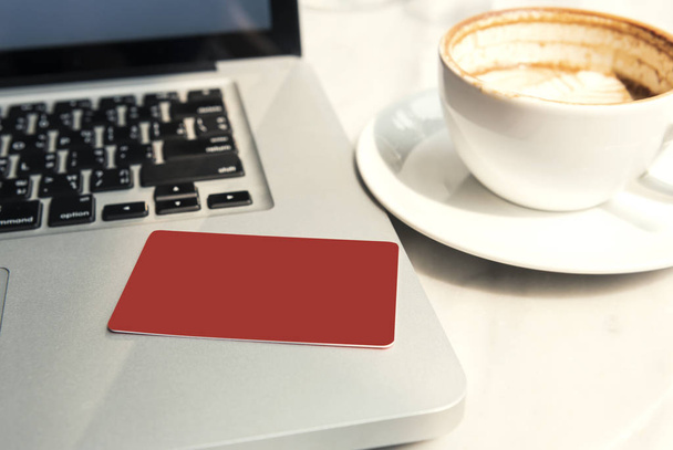 mockup tarjeta de crédito roja en el ordenador portátil en la cafetería
.  - Foto, Imagen