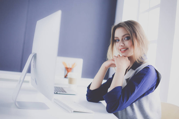 Young confident businesswoman working at office desk and typing with a laptop - Foto, imagen