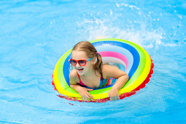 Child in swimming pool on toy ring. Kids swim. - Foto, Bild