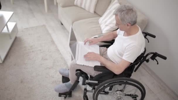 Homem com deficiência em uma cadeira de rodas digitando no laptop
 - Filmagem, Vídeo