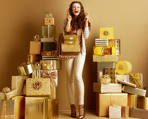 smiling fashion-monger with shopping bags and crossed fingers - Foto, Imagen