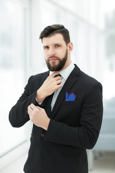 portrait of confident businessman adjusting his tie - Fotoğraf, Görsel