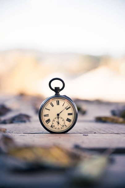El tiempo pasa: reloj vintage al aire libre; madera y hojas
; - Foto, Imagen