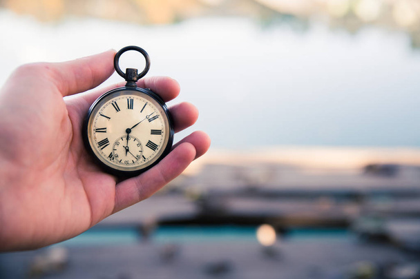Περνάει ο καιρός: vintage ρολόι σε εξωτερικούς χώρους, χειρός; ξύλο και τα φύλλα - Φωτογραφία, εικόνα