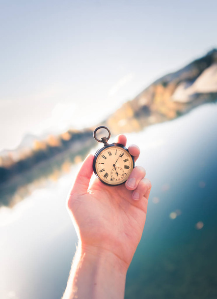 Reloj vintage de mano, vista otoñal con lago y árboles en el
 - Foto, imagen