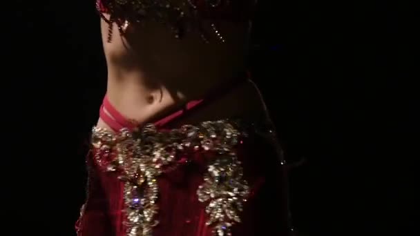 Torso of a belly dancer who is starting shaking her hips. Black background. Slow motion. Close up - Footage, Video