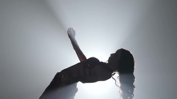 Chica bailando en vestido sobre fondo de humo. Sihouette. Movimiento lento
 - Metraje, vídeo