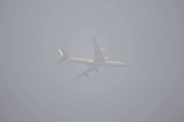 Над дымом и дымом пролетает размытый пассажирский самолет
  - Фото, изображение