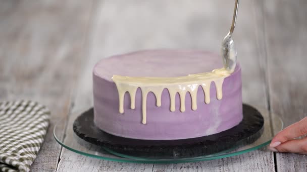 Primer plano de la preparación de un pastel en la cocina, verter glaseado de chocolate blanco en el pastel
. - Metraje, vídeo