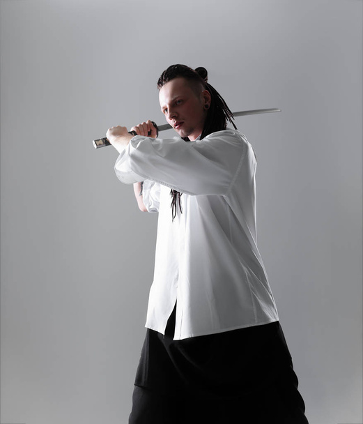 Young man holding a samurai sword. Glamour photo. - Fotó, kép