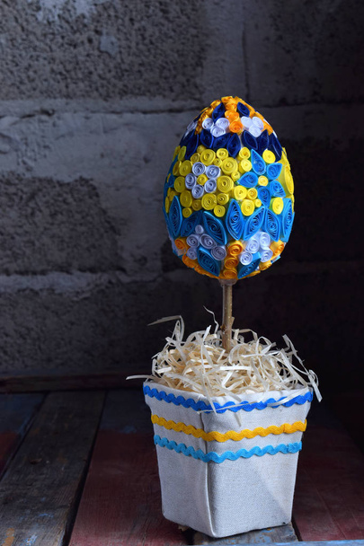 Топиарное яйцо выполнено в технике перьев на деревянном фоне. Пасхальные украшения или подарок ручной работы. Копирование пространства
 - Фото, изображение