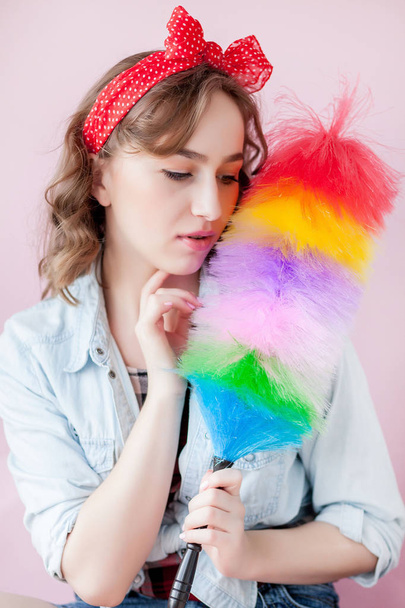 Cleaning pin up woman. Smiling pinup girl holds colorful duster  - Foto, afbeelding