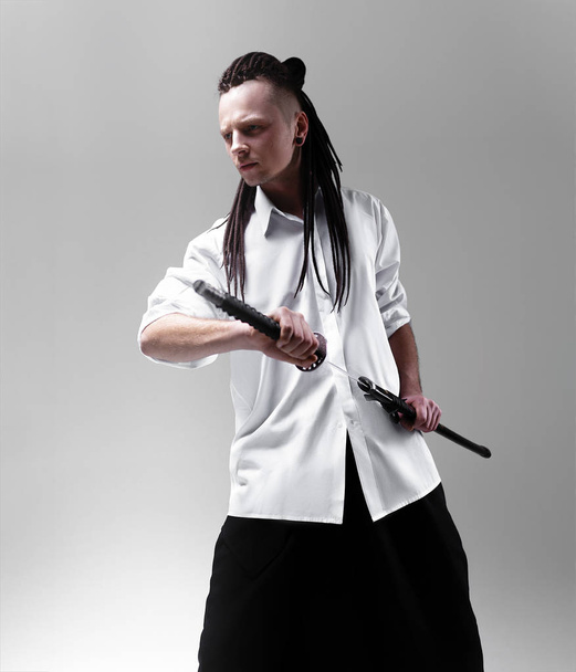 Young man holding a samurai sword. Glamour photo. - Фото, изображение