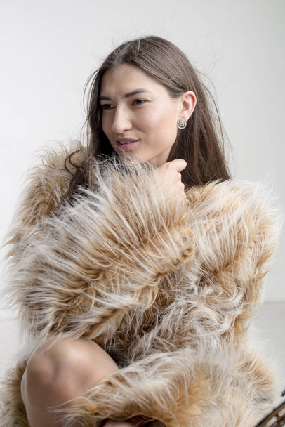 Beautiful model woman girl brunette in a fur coat - Фото, изображение