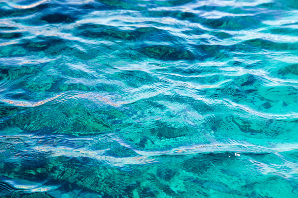 Rafa koralowa jest widoczne poprzez jasny niebieski wody. Piękne błękitne morze fala Fotografia z bliska. Wakacje na plaży morza lub oceanu. Podłoże do Wstawianie obrazów i tekstu. Turystyka, Podróże. - Zdjęcie, obraz