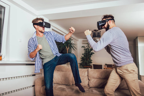 Des amis heureux jouant à des jeux vidéo avec des lunettes de réalité virtuelle - - Photo, image