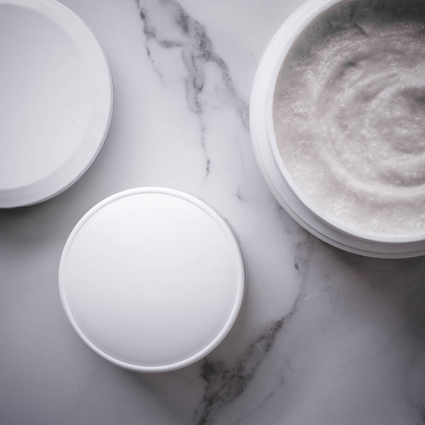 Frotar y productos de crema exfoliante en un mármol, flatlay
 - Foto, Imagen