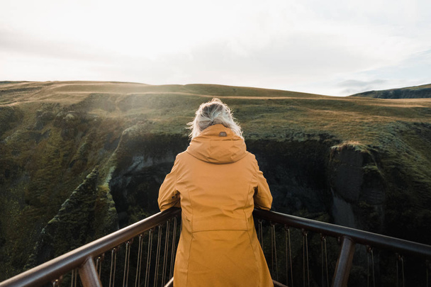 Taustakuva naisesta katselemassa Islannin pohjoismaista maisemaa
 - Valokuva, kuva